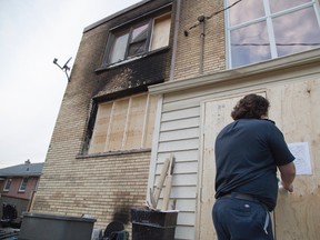 James Hind of the London Fire Department tapes an "order to close" notice on 1451 Oxford St. E. in London, Ontario on Wednesday, November 5, 2014. (DEREK RUTTAN, The London Free Press)