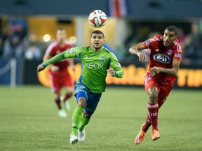 Seattle Sounders FC defender DeAndre Yedlin (17) and FC Dallas midfielder Tesho Akindele (13) pursue and errant pass during the first half at CenturyLink Field on Nov 10, 2014 in Seattle, WA, USA. (Joe Nicholson/USA TODAY Sports)