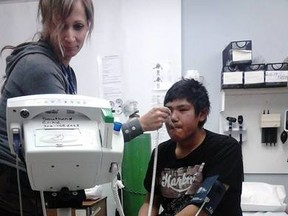 A nurse takes Braydon Morin's temperature at a health clinic in Southend, Sask. on Tuesday Nov. 11, 2014. Morin was one of five teenagers rescued from Malcolm Island, about 100km North of Southend after being missing for a week. Ann Morin/QMI Agency