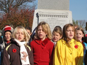 Children of the Chatham Christian Schools choir sing "In Flanders Fields" in front of the cenotaph in downtown Chatham during the Remembrance Day ceremony.