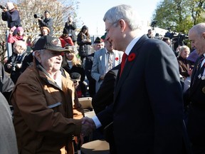 Prime Minister Stephen Harper and Minister of Veterans Affairs Julian Fantino greet the crowd during Remembrance Day ceremonies at the National War Memorial in Ottawa, Nov. 11, 2014. (CHRIS WATTIE/Reuters)