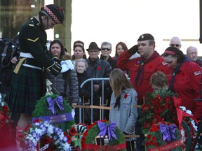 A family lays a wreath at the at Hamilton City Hall cenotaph Tuesday, Nov. 11, 2014, in front of a member of the Argyll and Sutherland Highlanders of Canada, slain soldier Cpl. Nathan Cirillo's reserve regiment. (CHRIS DOUCETTE/TORONTO SUN)