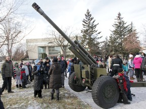 Winnipeggers mill around one of three guns that fired blank rounds during a Remembrance Day  Ceremony in Winnipeg.  Tuesday, November 11, 2014.  Chris Procaylo/Winnipeg Sun/QMI Agency