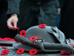 People lay poppies on the Tomb of the Unknown Soldier at the National War Memorial to mark Canada's observance of Remembrance Day in Ottawa on Tuesday, Nov. 11,  2014.  Tony Caldwell/Ottawa Sun/QMI Agency