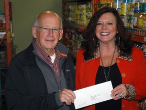 Terry E. Campbell, chairman of The Forever Legacy Foundation, hands a $19,000 cheque to Karen McDade, general manager of The Caring Cupboard Food Bank of St. Thomas. 

Ben Forrest/Times-Journal