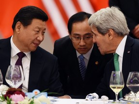 Chinese President Xi Jinping (L) speaks with U.S. State Secretary John Kerry (R), through a translator, during a lunch banquet in the Great Hall of the People in Beijing November 12, 2014. (REUTERS/Greg Baker/Pool)