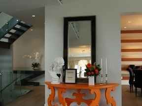 A wooden console table, painted a bright shade of orange, is a great way to add a pop of colour to your home. (Courtesy of Marco Antonio Homes)