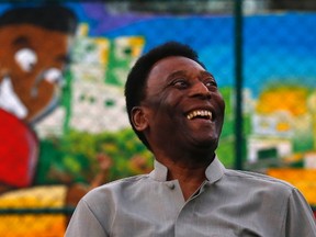 Brazilian soccer legend Pele laughs during the inauguration of a refurbished soccer field at the Mineira slum in Rio de Janeiro September 10, 2014. (REUTERS/Ricardo Moraes)