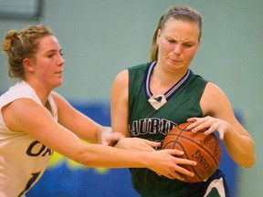 Laurier?s Nikita Chappell reaches for a loose ball with Oakridge?s Jessica Venhuizen during their TCRA Central Conferece AAA senior girls basketball final in Strathroy on Wednesday. The Oaks pulled away in the second half to win 49-36. (MIKE HENSEN/THE LONDON FREE PRESS)