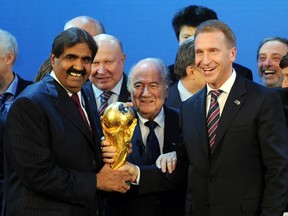 A file picture taken on December 2, 2010 shows the Emir of the State of Qatar Sheikh Hamad bin Khalifa Al-Thani (L), Fifa President Joseph Blatter (C) and Russia's Deputy Prime Minister Igor Shuvalov posing with the World Cup following the announcement that Russia and Qatar will host the 2018 and 2022 World Cups. (AFP PHOTO / PHILIPPE DESMAZES)