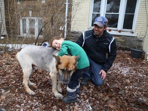 William Haskett, 4, hugs the family dog, Partner, as William's dad, Neil, looks on outside the family home in Sudbury, Ont., in this April 14, 2014 file photo. (JOHN LAPPA/QMI Agency)