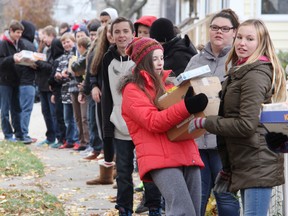 SCITS students and staff made a human chain Thursday to transfer donated food from the Sarnia high school to the Inn of the Good Shepherd. About 2,400 pounds of food was collected in the school's first Chain of Caring. Here Jacinda Bugler corrals a box of goods from fellow Grade 9 student Aimee Wilson. TYLER KULA/ THE OBSERVER/ QMI AGENCY