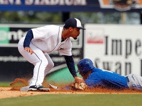 Ex-Tigers second baseman Devon Travis tags out Blue Jays’ Ryan Goins during a Spring Training game. Travis, acquired by Toronto on Wednesday, will “take Goins’ job for sure,” according to one National League scout. (USA TODAY SPORTS/PHOTO)