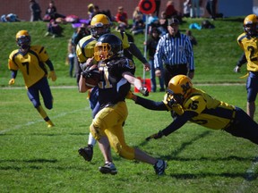 Central Elgin Collegiate Institute varsity football player Josh Butler (no. 21) streaks toward the end zone as Montcalm Cougars player Spencer Swan, right, tries to tackle him.  (File photo)