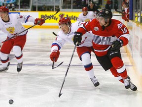 OHL All-Stars' Max Domi knocks the puck away from Team Russia's Dmitry Yudin during Super Series action on November 13, 2014 at the Peterborough Memorial Centre. (Clifford Skarstedt/Peterborough Examiner/QMI Agency)