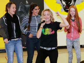 UPower's Sara Westbrook motivates while students dance in the background at a presentation in Sarnia earlier this month. (QMI Agency)