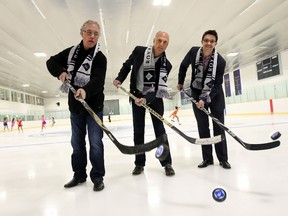 Board members Warren Jones, left, Jake Burlet and William Milroy shoot pucks during the grand reopening of the ice rink at Royal Glenora on Thursday. (Perry Mah, Edmonton Sun)