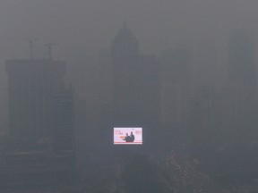 WIRE PHOTOS OF THE WEEK NOV 3 -- An electronic screen is seen on a building amid heavy smog in Shenyang, Liaoning province October 28, 2013. China's Health Ministry will set up a national network within five years to provide a way of monitoring the long-term impact of chronic air pollution on human health, state media said on Monday. Picture taken October 28, 2013. REUTERS/Stringer