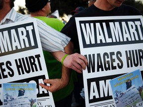 Demonstrators link arms as they block the street during a protest for better wages and working conditions outside a WalMart during Black Friday in San Leandro, Calif., Nov. 29, 2013. (STEPHEN LAM/Reuters)