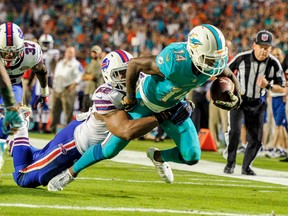 Miami Dolphins wide receiver Jarvis Landry dives for a touchdown as Buffalo Bills linebacker Preston Brown (52) hangs on during NFL play Thursday, Nov. 13, 2014 in Miami. (Brad Barr/USA TODAY Sports)