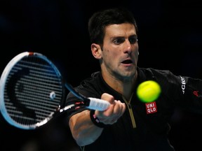 Novak Djokovic hits a return to Tomas Berdych during their match at the ATP World Tour Finals at the O2 Arena in London November 14, 2014. (REUTERS/Stefan Wermuth)