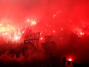 Olympiakos' fans light up flares before their Greek Super League soccer match against Panathinaikos at Karaiskaki stadium in Piraeus, near Athens, October 26, 2014. (REUTERS/Alkis Konstantinidis)
