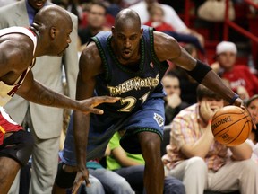 Miami Heat center Shaquille O'Neal (L) defends Minnesota's Wolves forward Kevin Garnett during NBA action in Miami, Florida January 1, 2006. (REUTERS/Marc Serota)