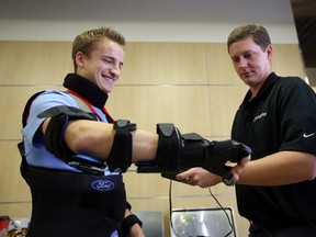 Ford human factors engineer, Cary Diehl, right, puts the "third age” safety suit on MacEwan University engineering student Kurt Radostits at the Robbins Health Learning Centre in Edmonton, AB  on Friday, November 14, 2014. The suit helps car designers create vehicles taking in mind various disabling human factors including cataracts, glaucoma, Parkinson’s and other degenerative diseases. PERRY MAH/EDMONTON SUN