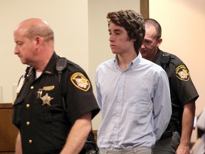 Chardon High School suspected gunman TJ Lane (C) is escorted into court for his court appearance, by Sheriffs deputies in Chardon, Ohio in this file photo from  May 24, 2012.  Lane, convicted of killing three students in a 2012 shooting rampage at a Cleveland-area high school escaped with another inmate from a prison in northwestern Ohio, prompting a manhunt for the pair, police said on September 11, 2014.    REUTERS/Aaron Josefczyk/Files