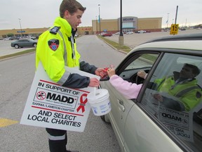 Jeremy Nopper, a paramedic student at Lambton College, mans a Red Ribbon tolls Saturday at Lambton Mall, collecting donations for Mothers Against Drunk Driving. About 100 volunteers were expected to be out at shopping centres in Sarnia, Wyoming, Petrolia and Corunna manning tolls from 10 a.m. to 4 p.m. PAUL MORDEN/THE OBSERVER/QMI AGENCY