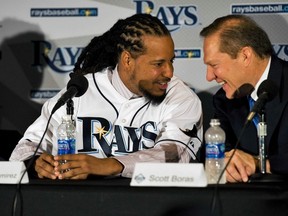 Free agent Manny Rodriguez (left) talks with agent Scott Boras during a news conference where he was introduced after signing a one-year contract with the Tampa Bay Rays February 1, 2011. (REUTERS/Steve Nesius)