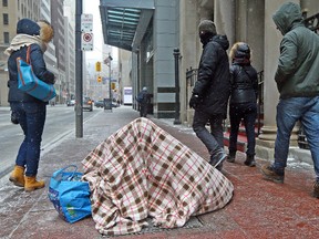 Despite the what feels like in the -20's homeless brave the cold along Bay St in Toronto on Sunday January 26, 2014. (Dave Abel/QMI Agency files)
