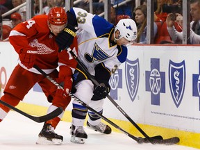 Detroit Red Wings centre Gustav Nyquist and St. Louis Blues defenceman Jordan Leopold (33) battle for the puck at Joe Louis Arena. ( Rick Osentoski/USA TODAY Sports)