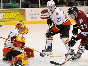 Belleville Bulls netminder Charlie Graham makes a stop on Guelph Storm forward Matthew Hotchkiss while defenceman Jack Hanley provides support during a 2-1 loss to the visitors Saturday night at Yardmen Arena. (Don Carr for The Intelligencer)