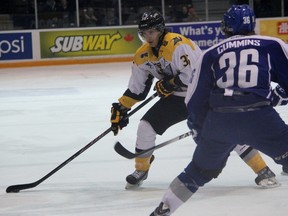 Sarnia's Nikita Korostelev corrals the puck with Sudbury Wolves defenceman Conor Cummins impeding his path to the net. Sarnia scored four third-period goals to secure a 5-2 victory. (TERRY BRIDGE/THE OBSERVER)