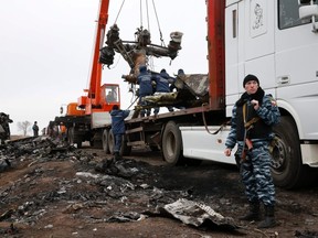 Local workers carry wreckage from the downed Malaysia Airlines flight MH17 at the site of the plane crash near the village of Hrabove (Grabovo) in Donetsk region, eastern Ukraine Nov. 16, 2014. REUTERS/Maxim Zmeyev