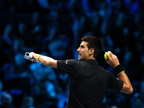 Novak Djokovic of Serbia throws a ball for the umpire to catch as he jokes during an exhibition match against Andy Murray of Britain at the ATP World Tour Finals at the O2 in London, November 16, 2014. Murray stepped in to play an exhibition match against Djokovic after Roger Federer of Switzerland withdrew from the men's singles final due to injury.  (REUTERS)
