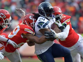 Seattle Seahawks running back Marshawn Lynch (24) is tackled by Kansas City Chiefs outside linebacker Tamba Hali (91) and strong safety Eric Berry (29) during the first half at Arrowhead Stadium. (Denny Medley-USA TODAY Sports)