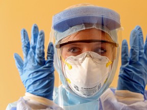 Emergency registered nurse Laura Moores wears personal protective equipment for treating patients with such infectious diseases as Ebola virus at Belleville General Hospital in Belleville, Ont. Thursday, October 30, 2014. Quinte Health Care has improved protection for workers based on feedback from staff who treated a patient suspected of having Ebola. The corporation is now sharing that knowledge with other hospitals. Luke Hendry/The Intelligencer/QMI Agency