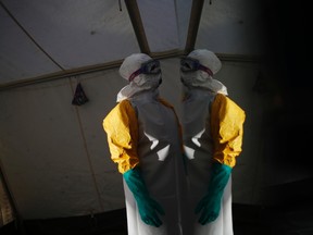 A worker in her protective suit stands in the dressing area during an Ebola training session held by Spain's Red Cross in Madrid October 29, 2014. REUTERS/Susana Vera files