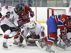 Kingston Voyageurs' Adam Moodie, left, looks for the loose puck in front of Mississauga Chargers goaltender Alex Lepore  during the first period of Ontario Junior Hockey League action at the Invista Centre on Sunday. (Julia McKay/The Whig-Standard)