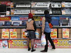 People try out laptops displayed at an electronics retail store in Tokyo November, 16, 2014.  REUTERS/Yuya Shino