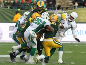 Edmonton Eskimos defence forces Saskatchewan Roughriders' Kerry Joseph to throw early during first half CFL action at Commonwealth Stadium in Edmonton, AB on Sunday, November 16, 2014. (Perry Mah/Edmonton Sun/QMI Agency)