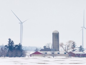 A farm stands in the foreground as some of the 45 wind turbines at the Bornish Wind Energy Centre stand in the distance near Parkhill. (Free Press file photo)