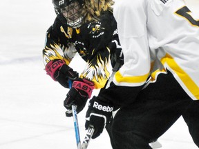 Cassidy Smith (left) of the Mitchell U14A ringette team checks this Elora-Fergus opponent during WORL action last Thursday, a 4-3 win. ANDY BADER/MITCHELL ADVOCATE