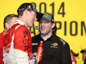 Driver Kevin Harvick (left) and team owner Tony Stewart celebrate winning the Ford EcoBoost 400 and Chase for the Championship title on Sunday. (Getty Images/AFP)