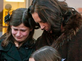 Michelle Kropp comforts her tearful daughters Maggie, 8, and Jayme, 11 outside the Provincial Court of Alberta in Sherwood Park. After a three-hour session in court, the judge ruled that Kropp, who has a potbellied pig named Eli, must pay a $100 fine for harbouring livestock, which is not allowed under the Strathcona County bylaw. Megan Voss/Sherwood Park News/QMI Agency