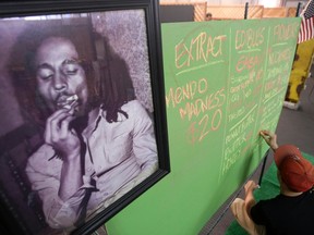 A portrait of reggae legend Bob Marley hangs next to a menu of marijuana products at the medical marijuana farmers market at the California Heritage Market in Los Angeles, California in this file photo taken July 11, 2014. The family of Reggae icon Bob Marley and a Seattle-based private equity firm on November 18, 2014, said they are launching the first global cannabis brand with marijuana products sold under a name long tied to a plant he lovingly called "the herb".  REUTERS/David McNew/Files