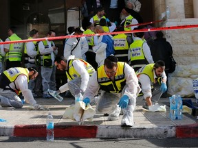 Members of the Israeli Zaka emergency response team clean blood from the scene of an attack at a Jerusalem synagogue on November 18, 2014. (REUTERS/Ammar Awad)