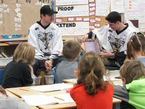 Justin Fazio of the Sarnia Sting reads to a group of students at St. Philip's school in Petrolia while teammate Taylor Dupuis looks on. (BRENT BOLES, QMI Agency)